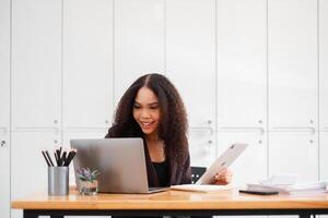 alegre empresária multitarefas, trabalhando com uma computador portátil e tábua às dela escritório mesa, exalando uma sentido do satisfação e produtividade. foto