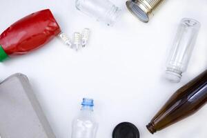 sortimento do reciclável materiais em uma branco superfície foto