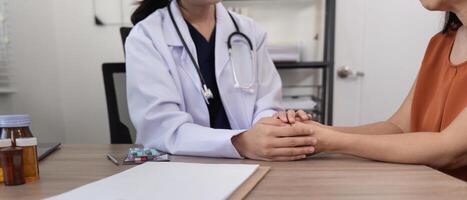 médico segurando paciente mão animar e encorajar enquanto verificação seu saúde foto