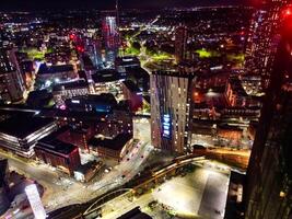 aéreo noite Visão do iluminado central Manchester cidade e centro da cidade edifícios, Inglaterra Unidos reino. pode 4º, 2024 foto