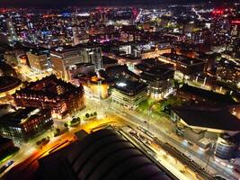 aéreo noite Visão do iluminado central Manchester cidade e centro da cidade edifícios, Inglaterra Unidos reino. pode 4º, 2024 foto