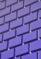 parede de concreto decorativa com relevo semelhante a uma grande alvenaria de tijolo pintada em tinta violeta brilhante foto