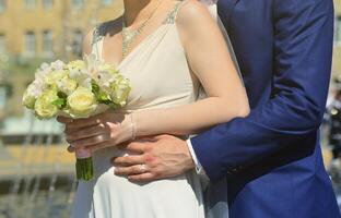 o casal recém-casado está segurando um lindo buquê de casamento. fotografia de casamento clássica, simbolizando unidade, amor e a criação de uma nova família foto