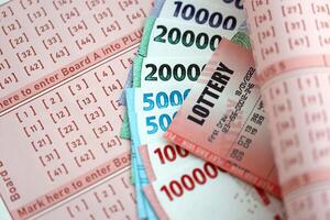 vermelho loteria bilhete mentiras em Rosa jogos de azar folhas com indonésio rupia dinheiro contas foto