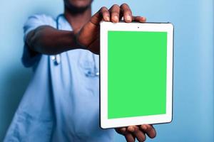 médico assistente segurando tablet digital com tela verde