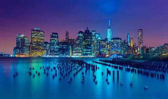 cidade de nova york à noite. horizonte de manhattan. arranha-céus refletidos na água. ny, eua foto