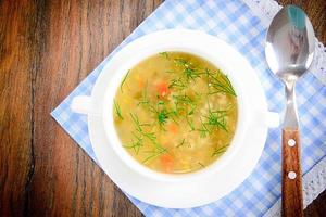 sopa de legumes em prato branco foto