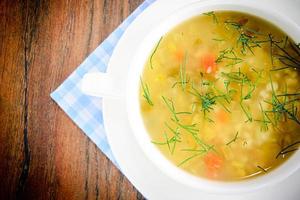 sopa de legumes em prato branco foto