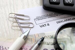 declaração para imposto em bens e Serviços IVA-8 Formato em contador mesa com caneta e polonês zloty dinheiro contas foto
