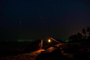 lanternas em a de praia dentro a Sombrio noite. foto