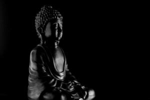 Buda purnima e vesak dia conceito, cinzento Buda estátua com baixo chave luz contra profundo Preto fundo foto