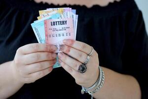 mulher mãos com indiano rupias contas e loteria bilhete. conceito do jogos de azar e ganhando dinheiro dentro indiano loteria foto