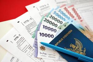 indonésio imposto formulários 1770 Individual renda imposto Retorna e Passaporte com caneta em mesa foto