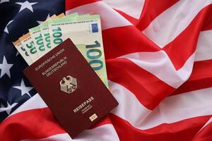 vermelho alemão Passaporte do europeu União e dinheiro em Unidos estados nacional bandeira fundo foto