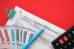 indonésio imposto Formato 1770 s - 2 Individual renda imposto Retorna e caneta em mesa foto