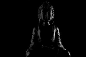 Buda purnima e vesak dia conceito, cinzento Buda estátua com baixo chave luz contra profundo Preto fundo foto