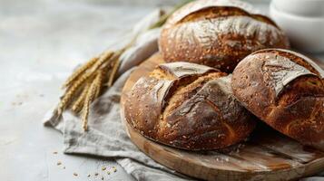 artesanal centeio pão com crosta, sementes, e trigo em uma de madeira corte borda foto