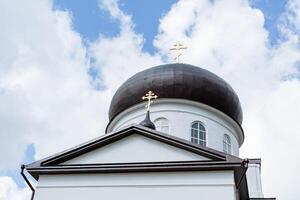 a ortodoxo cúpula do a têmpora sobe contra a céu, a dourado cruzes do a Igreja em a teto, a volta torre cúpula do a têmpora. foto