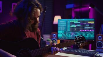 jovem homem jogando guitarra e criando música usando equalizador amanhecer Programas interface. música produtor gravação música dentro casa estúdio e mistura acústico sons em estéreo console. Câmera b. foto