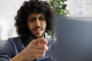 árabe executivo Gerente discutindo vendas crescimento plano com colegas de trabalho dentro ligar em computador portátil. começar acima empreendedor analisando relatório com analista dentro conferência dentro o negócio escritório foto
