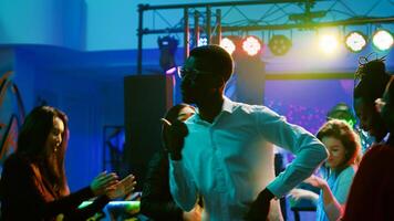 jovem pessoas festa às Boate tendo Diversão e bebendo álcool às bar, enérgico amigos dançando e desfrutando vida noturna. pessoas festa em a dança chão, funky boates. foto