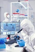 equipe do microbiologistas verificação evolução em coronavírus vacina dentro modelo laboratório. químico investigador durante global pandemia com covid-19 verificação amostra dentro bioquímica laboratório foto