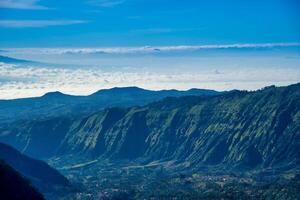 montanha com névoa em azul céu com nuvem dentro a manhã. foto