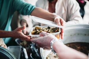 caridade comida, Comida para a pobre com fome voluntários oferta Comida para Socorro a sem teto a idéia do obtendo Socorro a partir de companheiro humanos foto