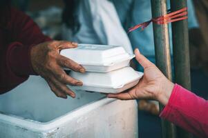 Comida assistência para a sem teto pobre a partir de voluntários conceitos do público fome. foto