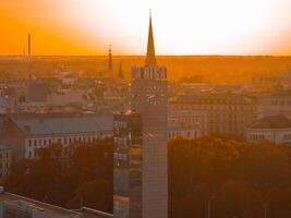 aéreo panorâmico pôr do sol sobre riga velho Cidade dentro Letônia. lindo Primavera pôr do sol sobre riga. riga relógio torre fechar acima Visão perto a trem estação. dourado hora fogo pôr do sol. foto