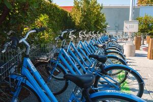 urbano bicicleta partilha estação com azul bicicletas alinhado foto