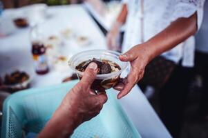 conceito do caridade Comida para a pobre . a conceito do vida problemas, fome dentro sociedade . ajudando pessoas com fome com gentileza. a mãos do mendigos receber doou Comida foto