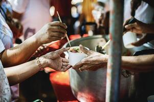 caridade comida, Comida para a pobre com fome voluntários oferta Comida para Socorro a sem teto a idéia do obtendo Socorro a partir de companheiro humanos foto