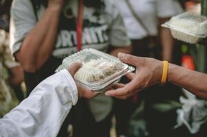 voluntários estão ajudando para dar livre Comida para a com fome morador de rua. Comida serviço e Comida doação conceito foto