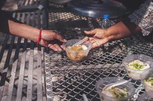 voluntários estão ajudando para dar livre Comida para a com fome morador de rua. Comida serviço e Comida doação conceito foto