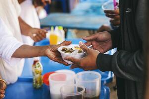 voluntários servindo quente refeições para com fome migrantes humanitário ajuda conceito. foto