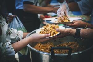 voluntários dar Comida para a pobre, compartilhar livre Comida para Socorro mendigos. Comida doação conceito foto