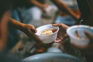 voluntários estão dando livre Comida para Socorro a com fome pobre conceito do Comida partilha foto