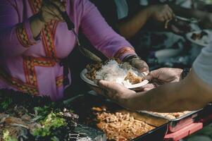 voluntários distribuir simples refeições para a pobre às a livre Comida cozinha. foto