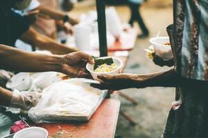 Comida assistência para a sem teto pobre a partir de voluntários conceitos do público fome. foto