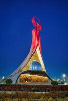 uzbequistão, Tashkent janeiro 4, 2023 iluminado monumento do independência dentro a Formato do uma estela com uma humo pássaro dentro a Novo uzbequistão parque às noite. foto