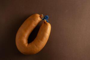 uma farinheira é uma tradicional Português linguiça fez com farinha, carne de porco gordo, e especiarias. dentro isto foto, isto senta em uma Castanho fundo, enfatizando Está laranja matiz e distintivo textura foto