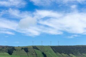 icônico vento turbinas ficar de pé alta no meio a cênico beleza do serra Faz cume montanha dentro terceira ilha, Açores. limpar \ limpo energia dentro uma pitoresco contexto. foto