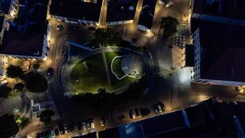 évora, alentejo, Portugal. pode 6, 2024. aéreo noite Visão do Évora jardim das canas e teatro garcia de resende. aceso caminhos tecer através a jardim, enquanto a teatro fachada brilha brilhantemente. foto