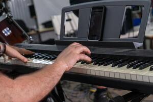 uma fechar-se do uma do homem mãos jogando a elétrico órgão. dele dedos mover rapidamente através a teclado, capturando a foco e precisão requeridos para desempenho. foto