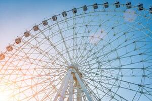 ferris roda às pôr do sol ou nascer do sol dentro a diversão parque. foto