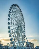 ferris roda às pôr do sol ou nascer do sol dentro a diversão parque. foto