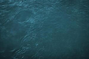 a textura do a ondas do azul cor do fluxo rápido água dentro a rio. foto