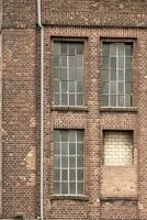 detalhes do a velho industrial prédio, tijolo parede e janelas, Aproximadamente. 100 anos velho foto