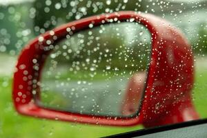 vermelho exterior espelho do uma carro dentro a chuva foto